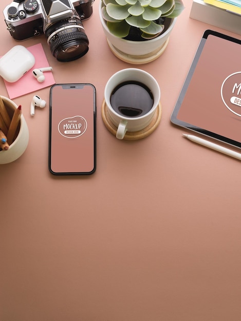 Chiuda in su dell'area di lavoro creativa rosa con il modello di smartphone