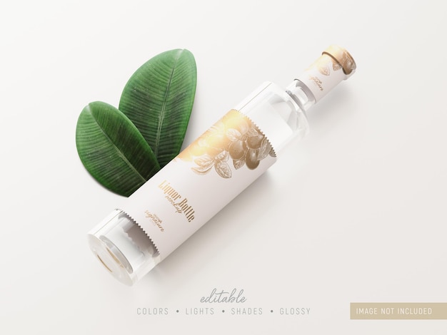 Clear glass liquor bottle mockup mit grünen blättern verziert