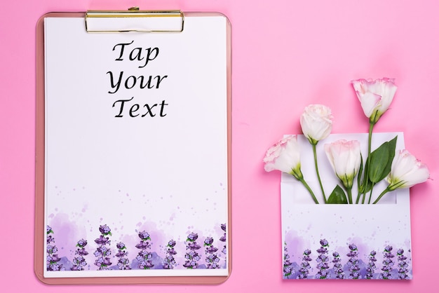 Clipboard with eustoma flower in envelope on pink paper
