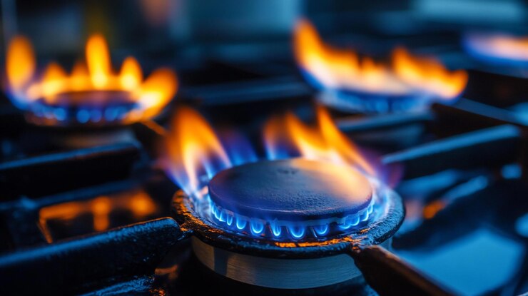 PSD close-up di bruciatori di stufe a gas con fiamme blu e arancioni vibranti