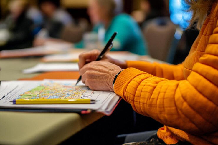 PSD close-up di mani che scrivono su una mappa durante una conferenza