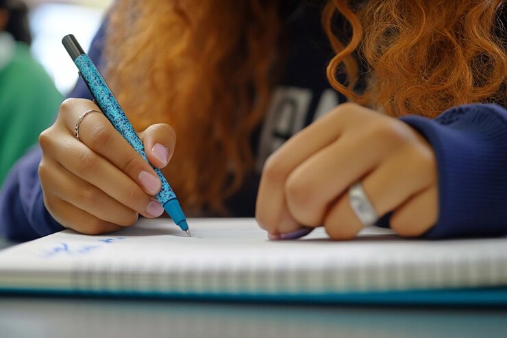 PSD close-up di una mano di uno studente che scrive in un quaderno