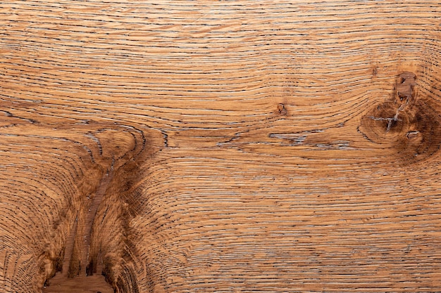 Close-up of a weathered oak wood surface with prominent grain and a knot