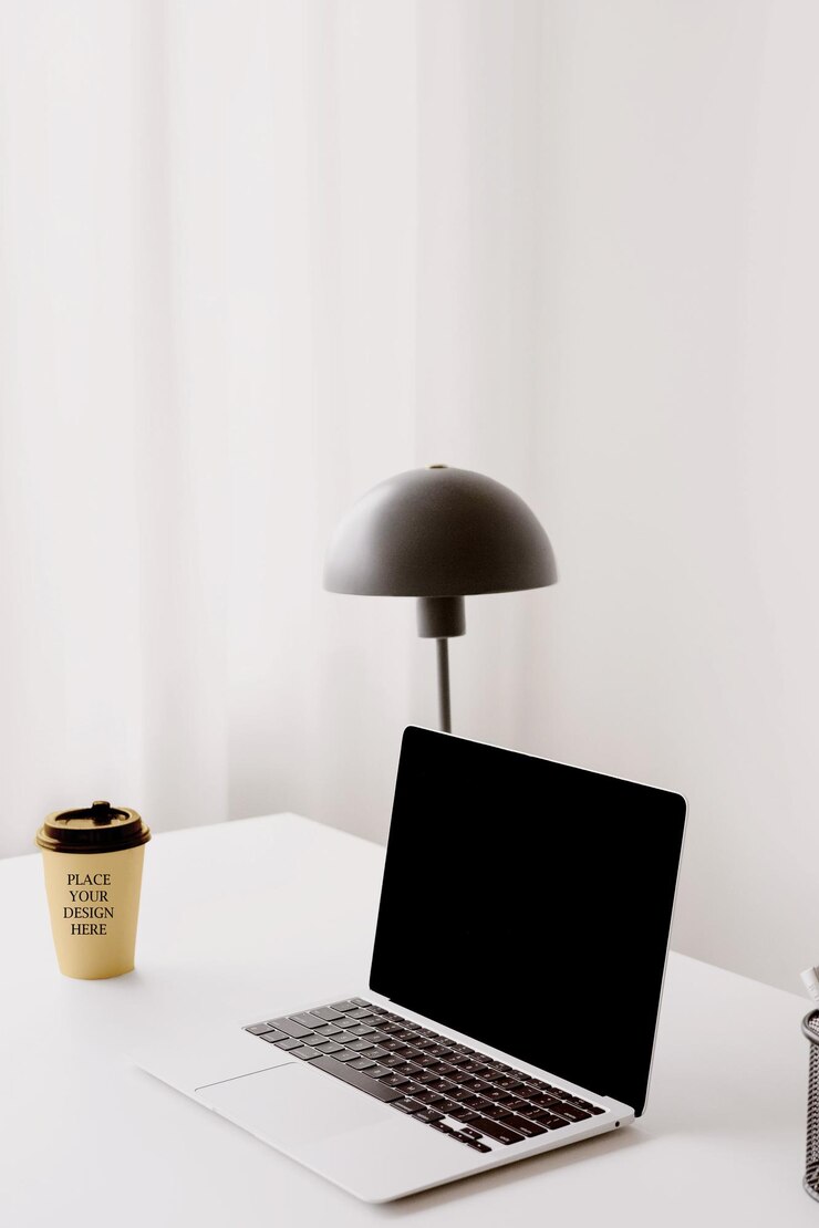PSD coffee cup mockup psd on white desk with laptop and lamp