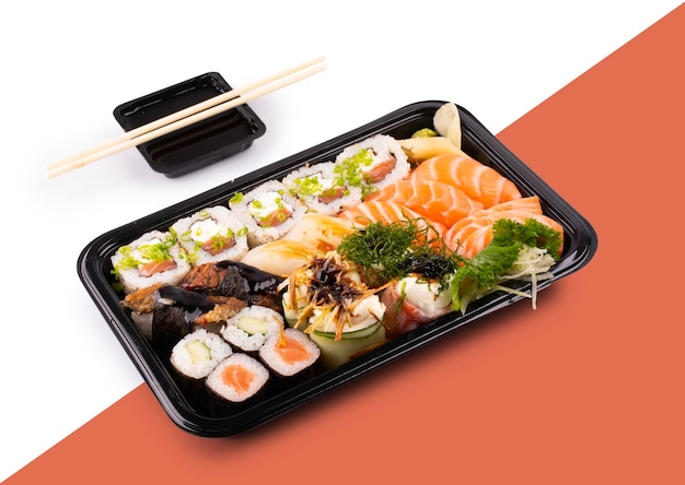 Combo-Träger mit mehreren Stücken orientalischer Sushi, roher Fisch, gesunder japanischer, farbenfroher, exotischer Lieferung mit Sojasauce und Stäbchen in einem Winkel