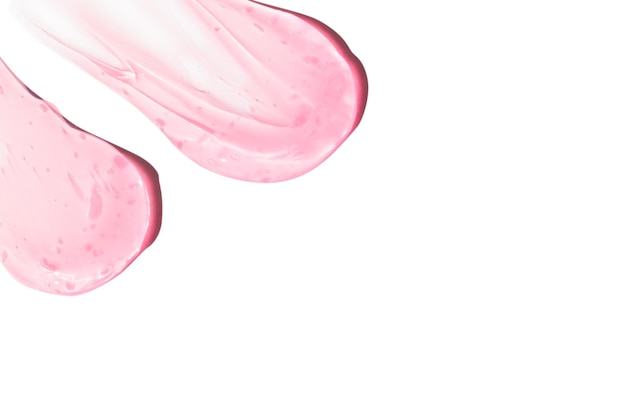 Composizione di smears e gocce o gocce di un siero gelico rosa trasparente su un vuoto