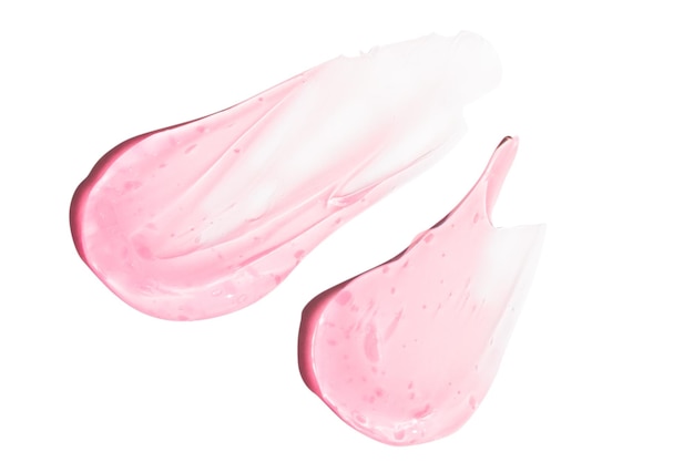 Composizione di smears e gocce o gocce di un siero gelico rosa trasparente su un vuoto