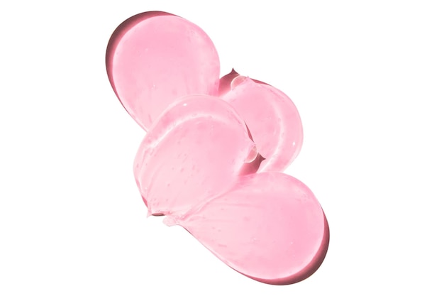 Composizione di smears e gocce o gocce di un siero gelico rosa trasparente su un vuoto