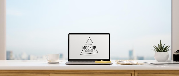 Computer laptop with mockup screen on the desk with panoramic window