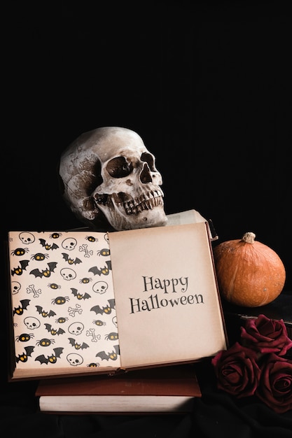 Concept d'Halloween avec tête de mort et livre sur fond noir