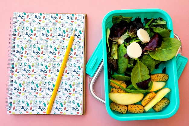 Concepto de comida para llevar con ensalada y libreta