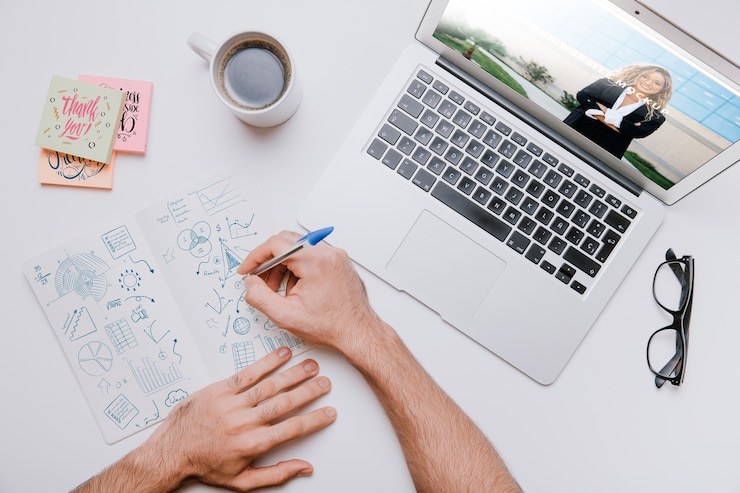 PSD concetto dell'area di lavoro con le mani che disegnano accanto al computer portatile