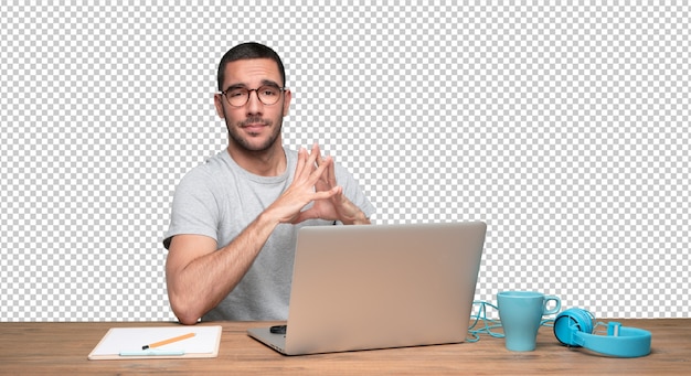 Confiante jovem sentado em sua mesa
