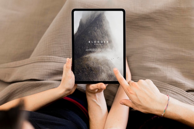 Coppia che usa un mockup di schermo tablet insieme a letto