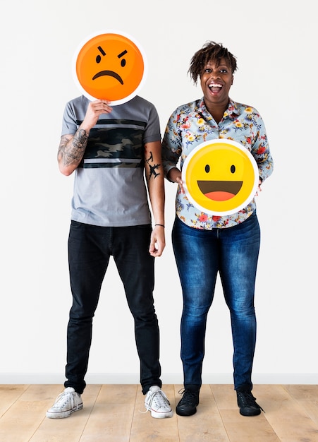 Coppie interrazziali che tengono un fronte espressivo dell&#39;emoticon