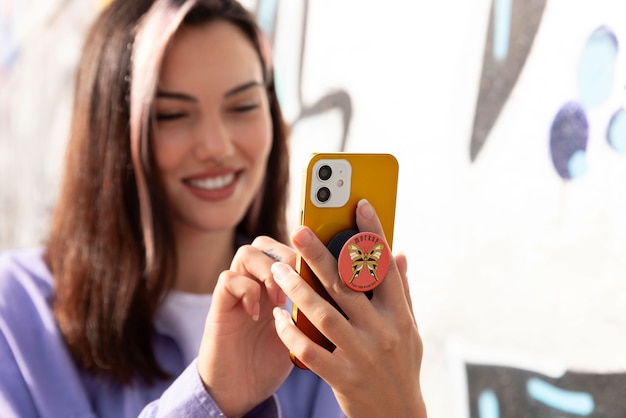 Coup moyen femme utilisant popsocket sur son téléphone