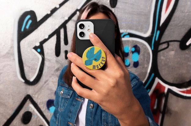 Coup moyen femme utilisant popsocket sur son téléphone