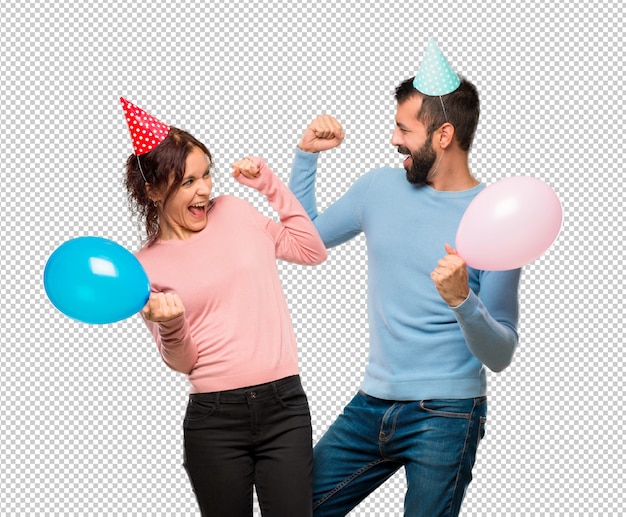 PSD couple avec des ballons et des chapeaux d'anniversaire célébrant une victoire en position gagnante