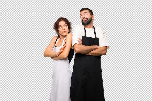 Couple de cuisiniers faisant un geste sans importance en soulevant les épaules