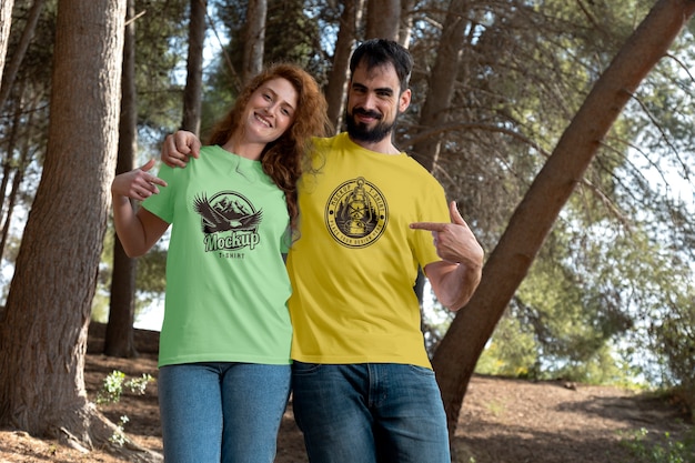 PSD couple à l'extérieur dans la nature portant une maquette de t-shirts