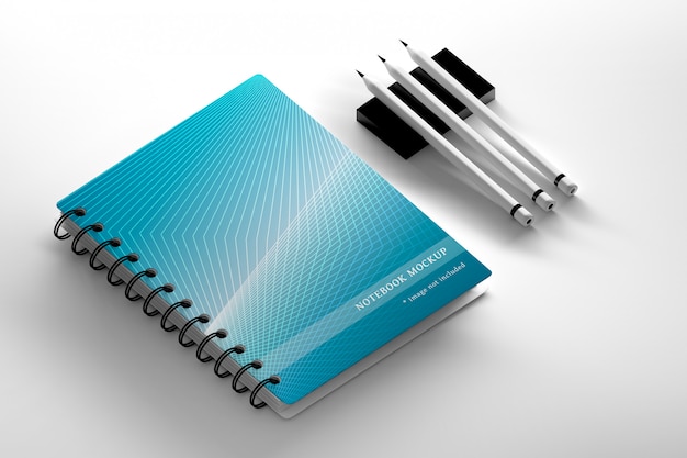 De capa de caderno espiral e três lápis de carbono na superfície branca