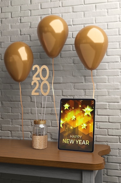 Decoraciones en la mesa junto a la tableta con mensaje para año nuevo