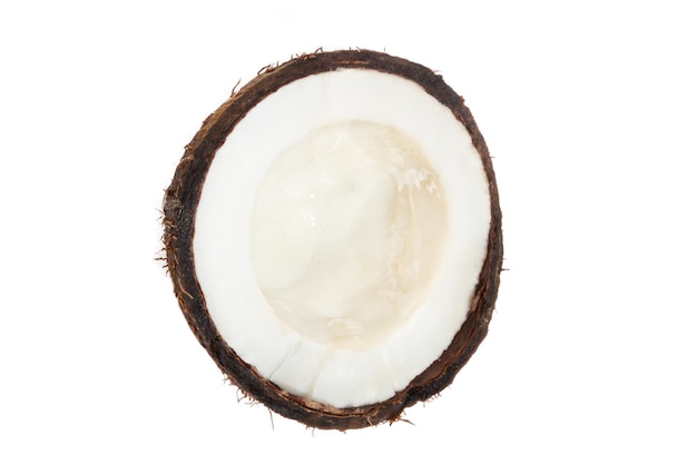 Une demi-noix de coco dans une coquille de noix de coco sur un fond blanc