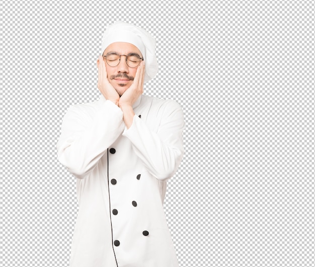 Descontraído jovem chef fazendo um gesto de sono