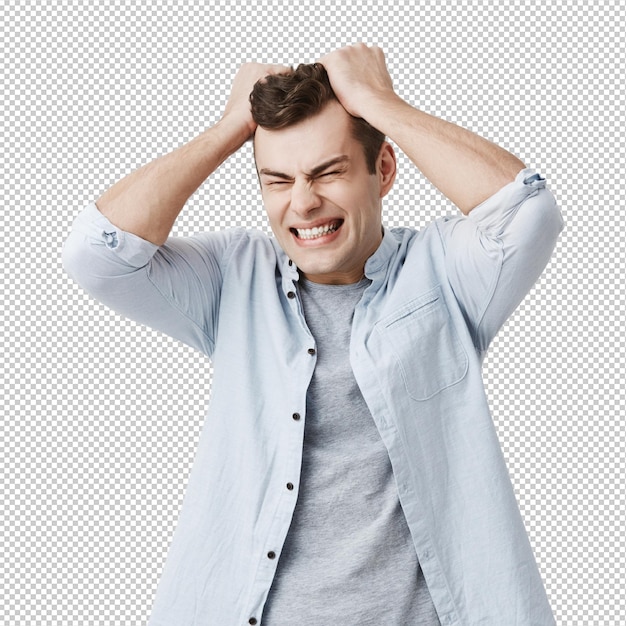 Desesperado irritado homem europeu franzeando a testa gritando de raiva com os olhos fechados rasgando o cabelo enquanto se sentindo furioso e zangado com algo expressões faciais negativas emoções e sentimentos