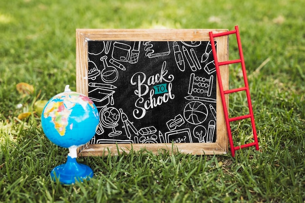 Di nuovo alla lavagna della scuola accanto al modello del globo della terra