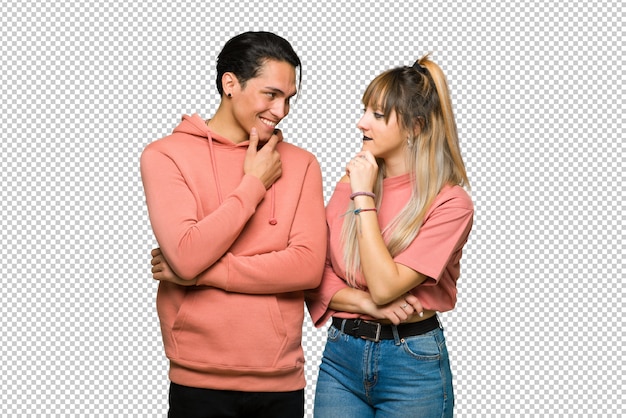 En el día de San Valentín Pareja joven mirando hacia un lado con la mano en la barbilla