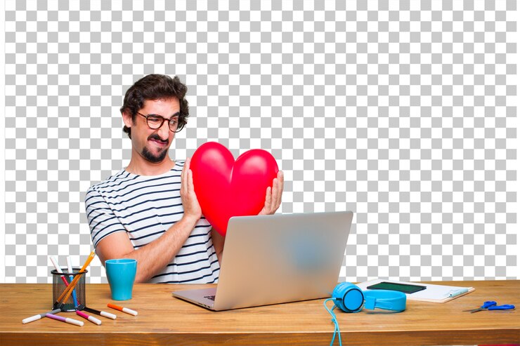 PSD diseñador gráfico loco joven en un escritorio con una computadora portátil y con una forma del corazón. concepto de amor