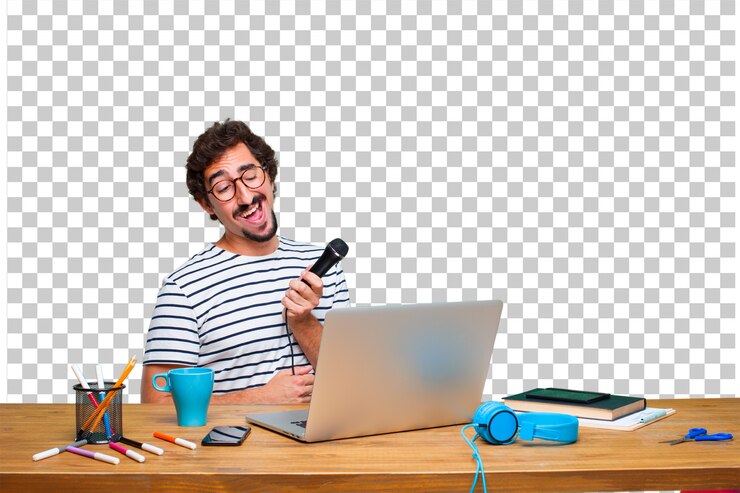 PSD diseñador gráfico loco joven en un escritorio con una computadora portátil y con un micrófono