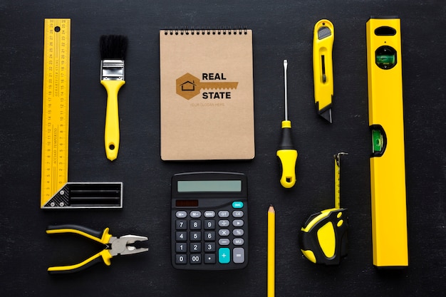 Disposition des différents outils de réparation avec maquette de bloc-notes sur fond noir