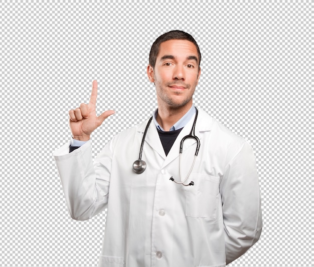 Doctor feliz que señala contra el fondo blanco