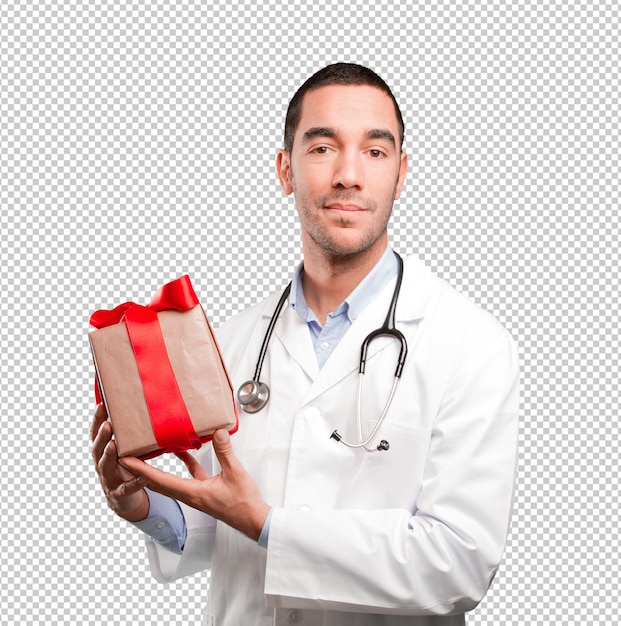 Doctor joven satisfecho que sostiene un regalo