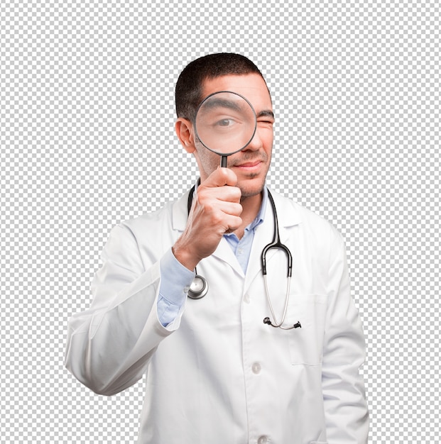 Doctor joven sorprendido que usa una lupa