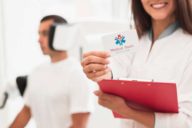 Doctora sonriente con tarjeta clínica de maqueta