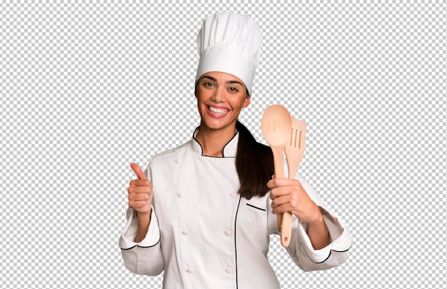 Donna adulta ed espressiva del cuoco unico ispanica con gli strumenti del cuoco
