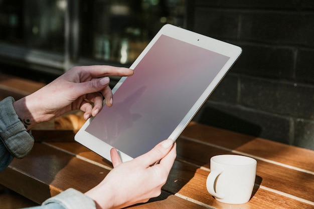 Donna che usa un tablet digitale in un modello di caffè