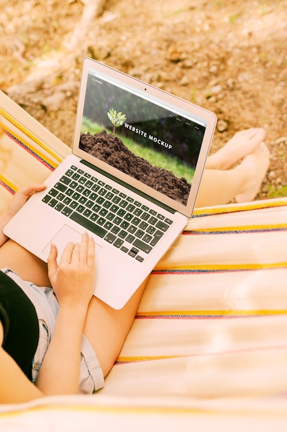 Donna che utilizza il modello del computer portatile in natura