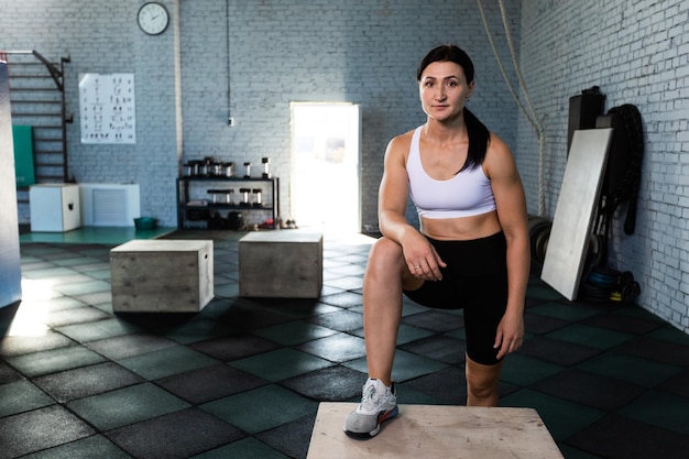 Donna in una palestra che fa un esercizio di salto in scatola