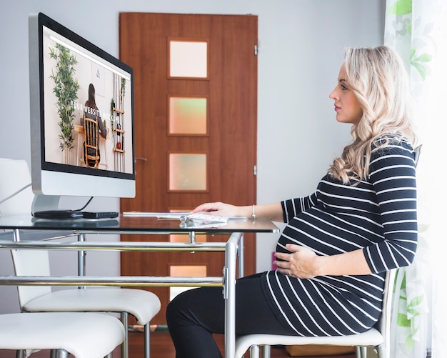 Donna incinta che per mezzo del computer