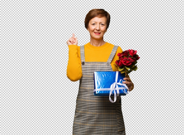 Donna invecchiata centrale che celebra il giorno di biglietti di S. Valentino che indica il lato con il dito