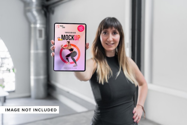 Donna sportiva felice che presenta il modello del tablet