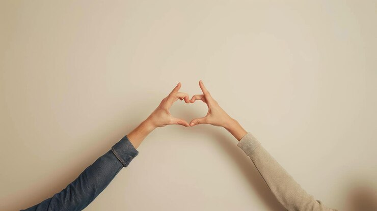 PSD dos manos que forman una forma de corazón contra un fondo beige