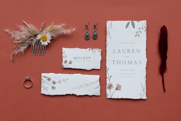 Draufsicht der rustikalen Hochzeitseinladung aus Papier mit Blättern und Blumen