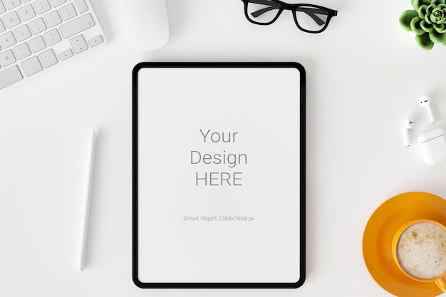 Draufsicht der Tablette des leeren Bildschirms auf weißem Schreibtischhintergrund.