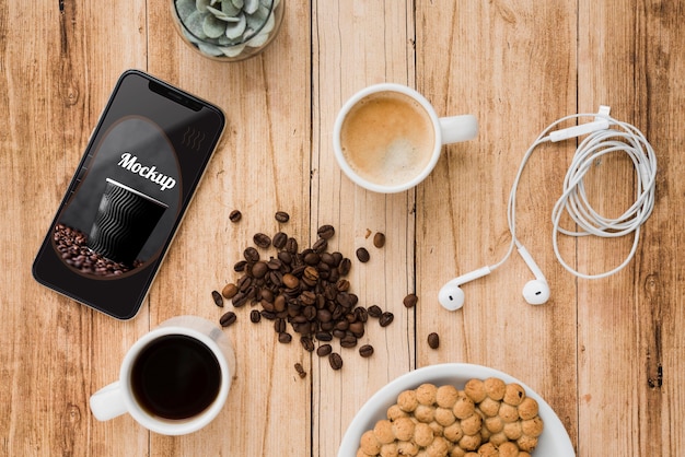 Draufsicht des Smartphones mit Kaffeebohnen und Tasse Tee