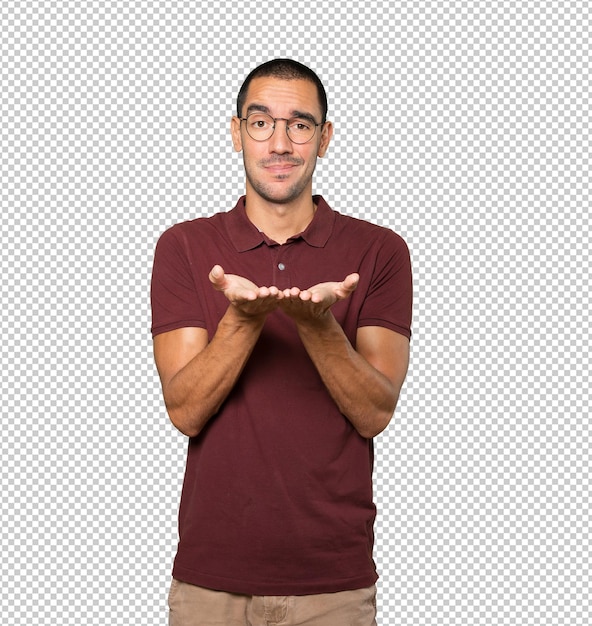 Dudoso joven sosteniendo algo con su mano